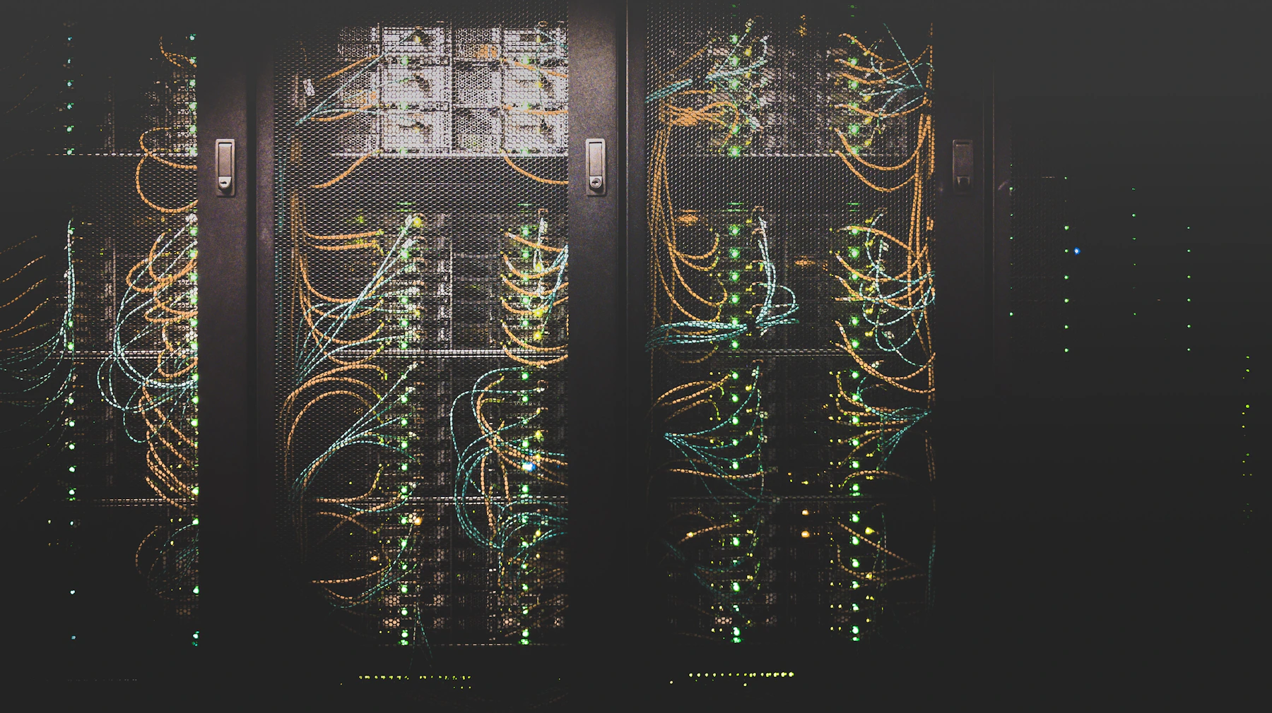 Corredor de servidores em um data center, com iluminação azul e cabeamento estruturado
